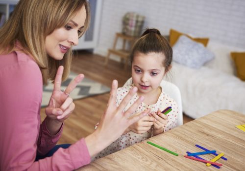 Young mum teaching child to count at home